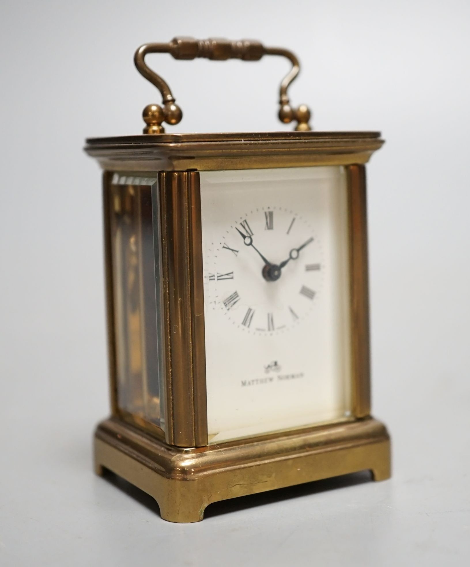 A Mathew Norman miniature brass carriage timepiece, 6cms high.